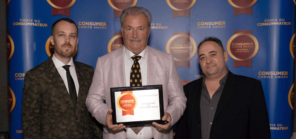 Three men stand together against a backdrop reading Consumer Choice Award, with the man in the center proudly holding a plaque. Representing City Wide Group, they are dressed in formal suits and ties, celebrating their recognition with dignity. Waterproofing Company | Basement Leak Repair | City Wide Group | Professional waterproofing company and basement leak repair in Toronto since 1961. | https://www.citywidegroup.com | +1 416-283-5500