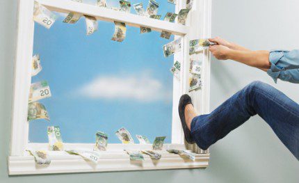 A person in jeans and black shoes leans out of a window, throwing Canadian dollar bills into the air. The sky is visible outside. Waterproofing Company | Basement Leak Repair | City Wide Group | Professional waterproofing company and basement leak repair in Toronto since 1961. | https://www.citywidegroup.com | +1 416-283-5500