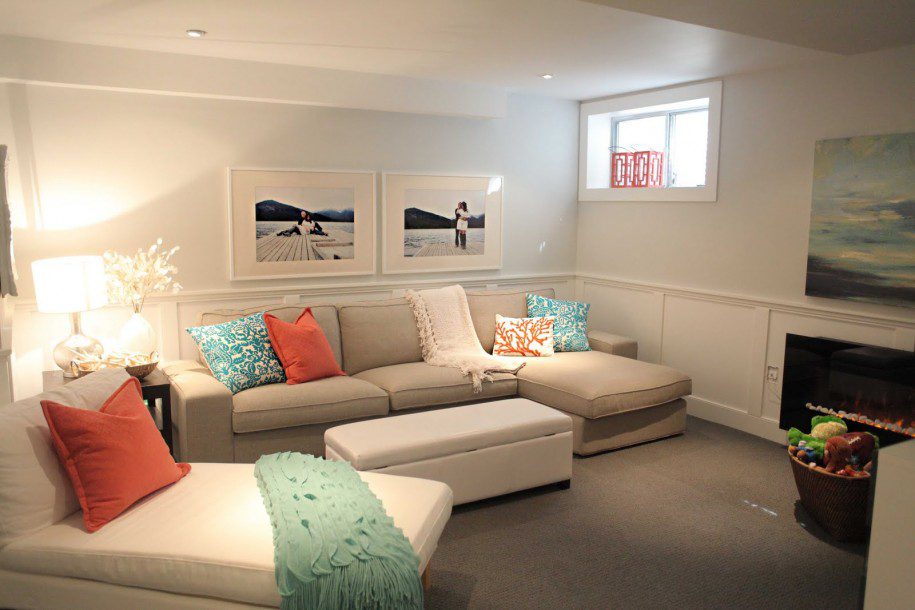 Stylish living room with a beige sectional sofa adorned with colorful throw pillows. A small window allows light in, and a Relax sign sits on the windowsill. A fireplace and decorative paintings add warmth and charm. Waterproofing Company | Basement Leak Repair | City Wide Group | Professional waterproofing company and basement leak repair in Toronto since 1961. | https://www.citywidegroup.com | +1 416-283-5500