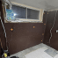 Partially finished basement room with brown dimpled waterproofing membrane on the walls, exposed pipes, electrical wires, and an uncovered window. The floor is unfinished with some tiles placed in one corner. Waterproofing Company | Basement Leak Repair | City Wide Group | Professional waterproofing company and basement leak repair in Toronto since 1961. | https://www.citywidegroup.com | +1 416-283-5500