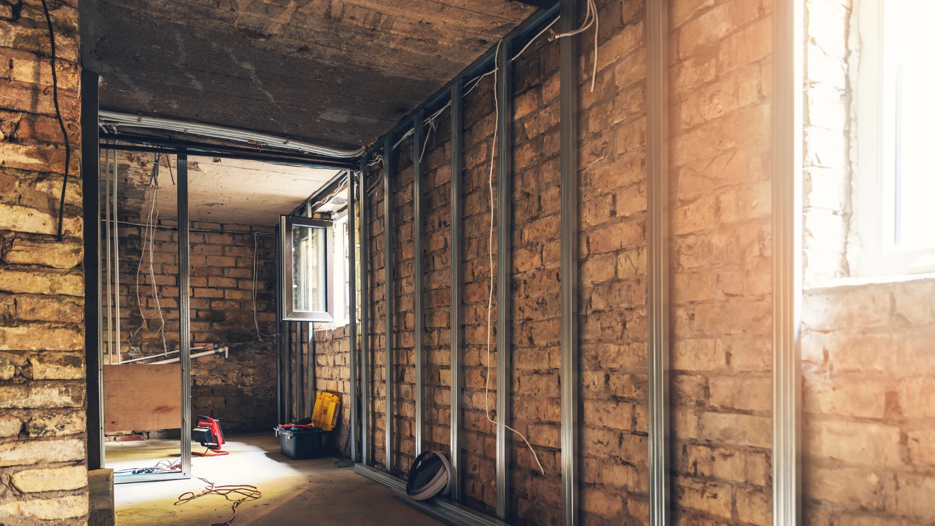 Homeowner reviewing a basement underpinning permit in Toronto with structural plans beside an exposed foundation wall